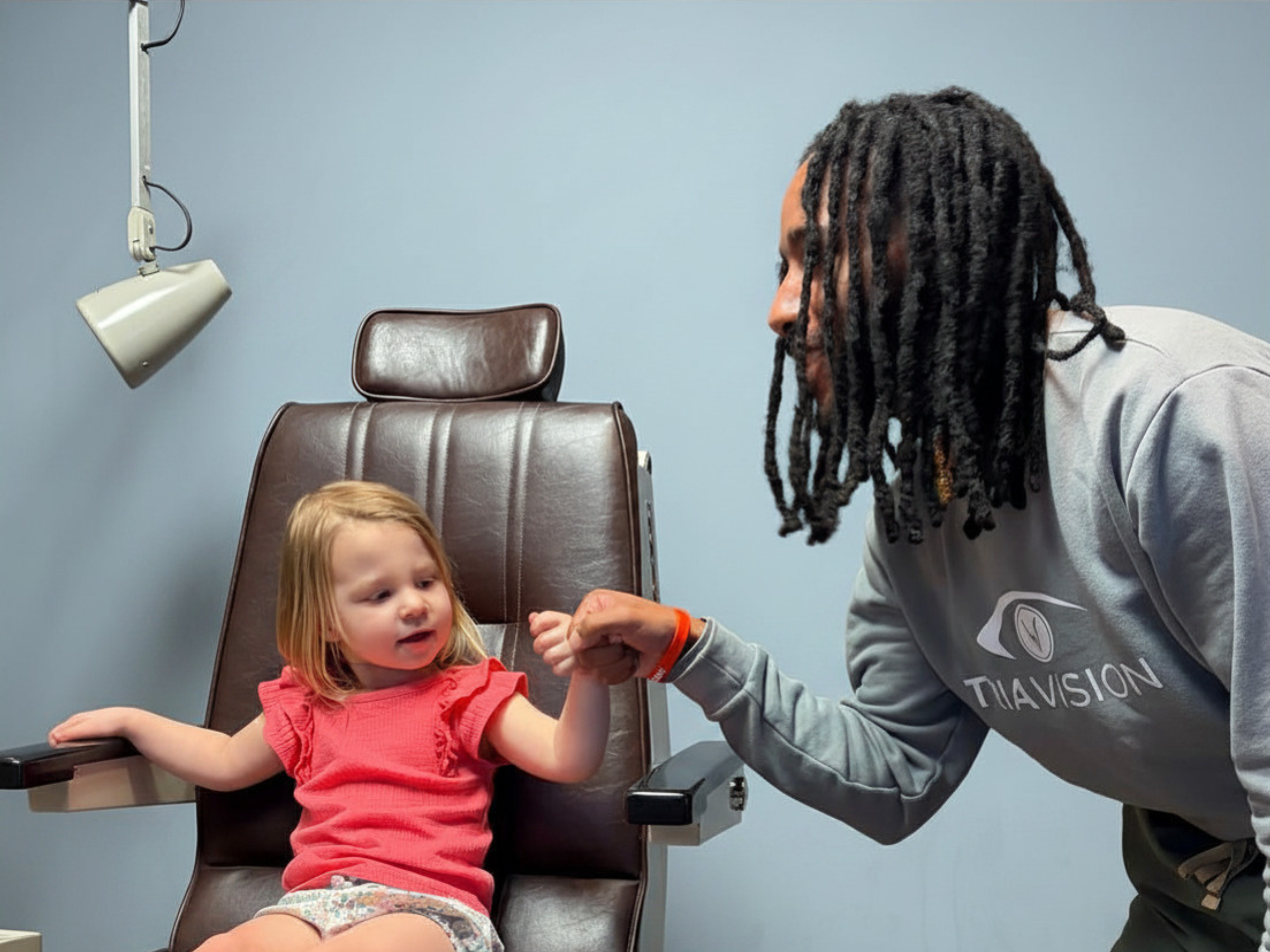 Jonathan fist bumps one of our pediatric patients after a successful eye exam!